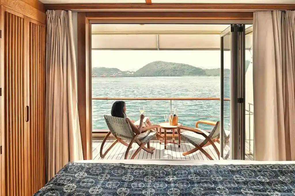 Guests on deck of a Phinisi boat cruising between islands